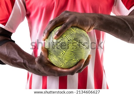 Midsection of african american male handball player wearing red uniform holding green ball. unaltered, sport, competition and match concept.