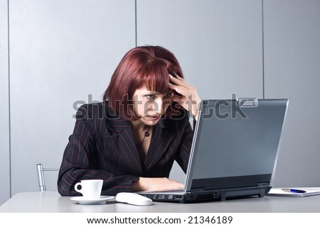 The concentrated beautiful business woman behind a desktop and the laptop