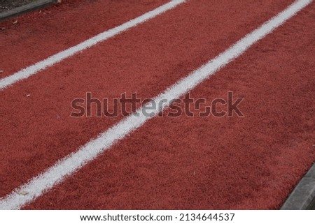 Close-up of the orange background texture with white lines in the outdoor track 