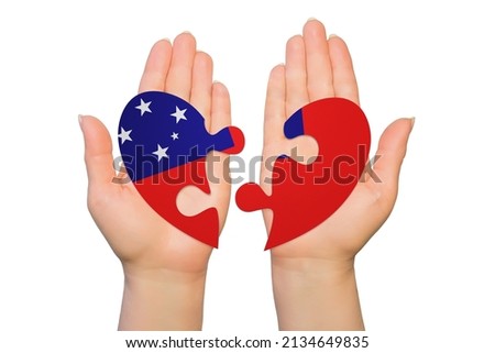 Woman hands are holding two parts of puzzle heart. National concept on white background. Samoa