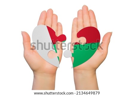 Woman hands are holding two parts of puzzle heart. National concept on white background. Madagascar