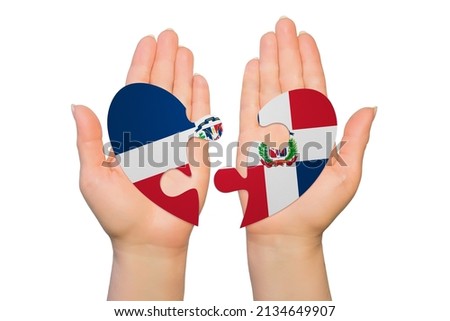 Woman hands are holding two parts of puzzle heart. National concept on white background. Dominican Republic