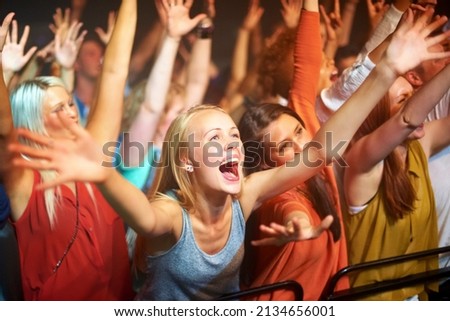 Caught up in the vibe. A huge group of fans screaming at a rock concert. Royalty-Free Stock Photo #2134656001