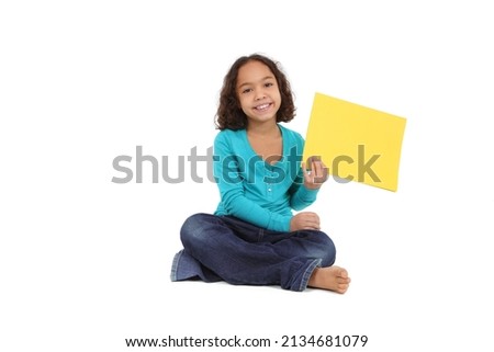 Smiling young girl holding a yellow sign