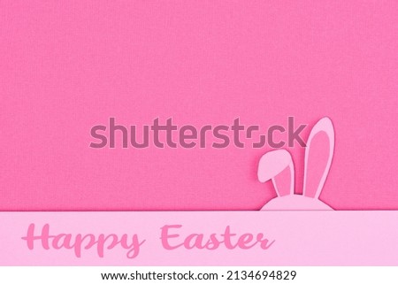 Bunny rabbit ears made of pink paper on pink background. Paper cut of colorful easter rabbit, and blue egg shape. Happy easter greeting card template. Easter minimal concept with copy space for text