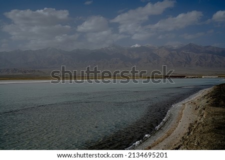 Chaka Salt Lake and Saline-alkali land landscape with blue sky and Snow mountain background in northwest China.