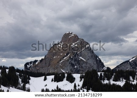 Great long exposure that stretches the clouds and a mighty mountain in the picture called Grosser Mythen in the canton of Schwyz in Switzerland with a small log cabin in the foreground.
