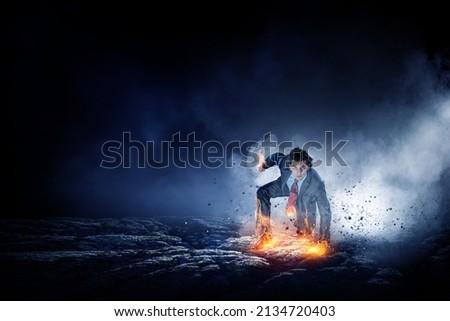 Determined businessman leaving fire trails on asphalt Royalty-Free Stock Photo #2134720403