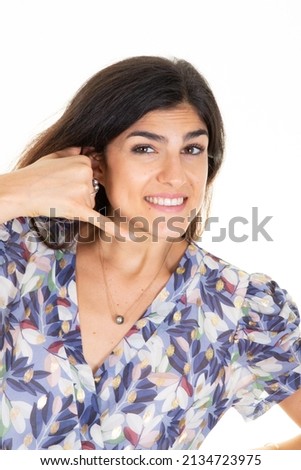 Woman smiling make phone sign gesture call me back with hand and fingers like talking on phone cell 