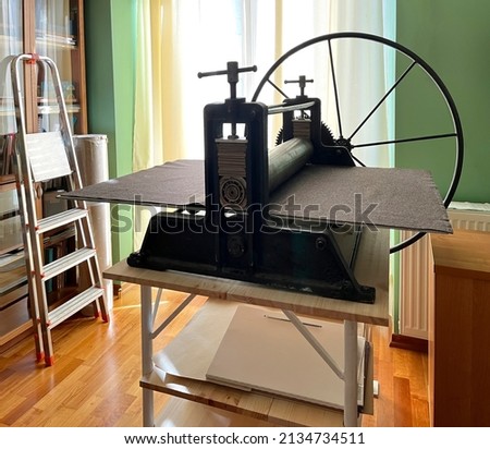 Etching press for printmaking Art equipment in studio. Ancient engraving old machine. Space for text. Linocut, woodcut, etching, monotype, print, embossing, stamp art printing step process hand made

 Royalty-Free Stock Photo #2134734511