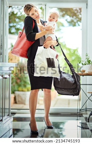 Being a mother is a full time job. Shot of a busy businesswoman carrying groceries and her baby while talking on the phone on her return from work. Royalty-Free Stock Photo #2134745193