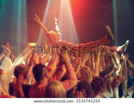 A young man crowd surfing to his favorite band. This concert was created for the sole purpose of this photo shoot, featuring 300 models and 3 live bands. All people in this shoot are model released. Royalty-Free Stock Photo #2134745259