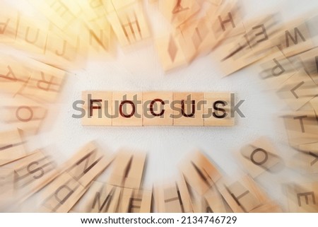 Top view of Focus word on wooden cube letter block on white background. Business concept with radial zooming blur effect
