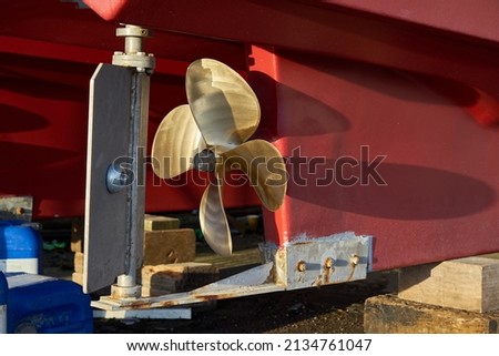 The rudder and propeller of a boat in dry dock Royalty-Free Stock Photo #2134761047