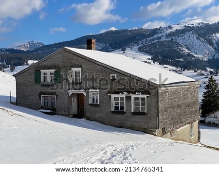 Traditional Swiss architecture and wooden alpine houses in the winter ambience of fresh white snow cover, Unterwasser - Obertoggenburg, Switzerland (Schweiz)