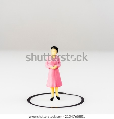 a miniature model of a woman isolated inside a circle drawn on a surface