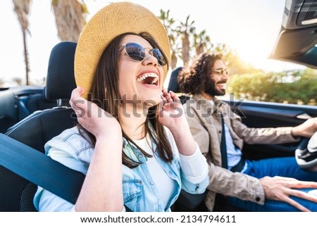 Happy couple driving convertible car enjoying summer vacation - Friends rent cabrio auto on holiday - Roadtrip, freedom, travel and transport rental service concept	 Royalty-Free Stock Photo #2134794611