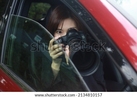 A woman taking a picture from inside the car 