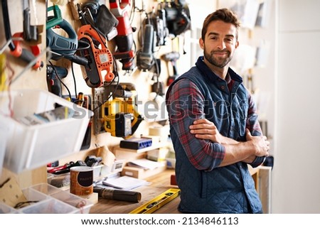 Lets fix it. Portrait of a handsome young handyman standing in front of his work tools. Royalty-Free Stock Photo #2134846113