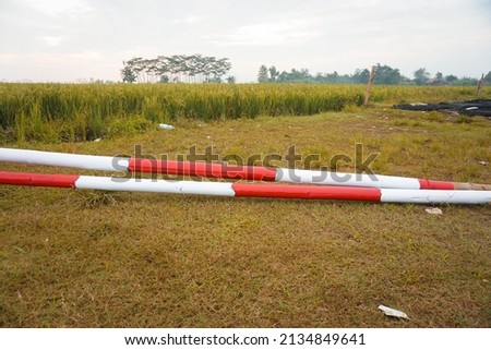 
two red and white bamboo poles lying on the field