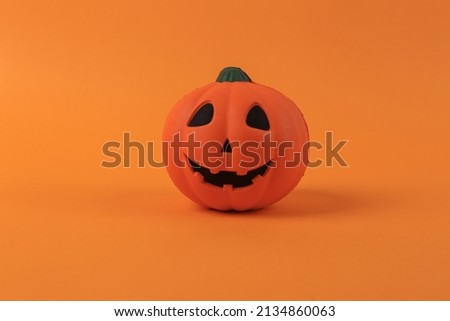 Antistress toy, pumpkin jack lantern head on orange background. Halloween concept. Minimal still life photo