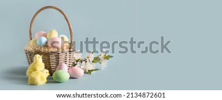 Easter wicker basket with pastel eggs for Happy holiday and celebration on blue background. Banner. Greeting card. Royalty-Free Stock Photo #2134872601