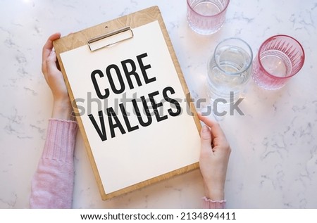 Core Values - text inside notebook on table with hands.