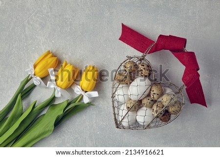 Chicken and quail eggs in a heart shaped woven metal wire basket