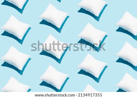 Pattern made of white pillow on serenity pastel blue background. Sleeping concept. Isometric flat lay.
