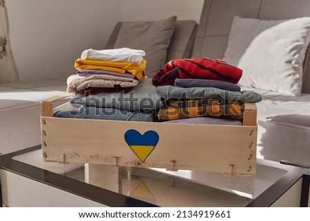 Help volunteering donation concept. Donation box full of clothes at home Royalty-Free Stock Photo #2134919661
