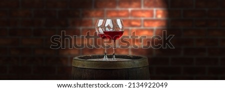 Wine glasses with tall stem. Old oak barrel in a dark wine cellar at the winery. Aging cellaring wine tasting from vintage vineyard Royalty-Free Stock Photo #2134922049