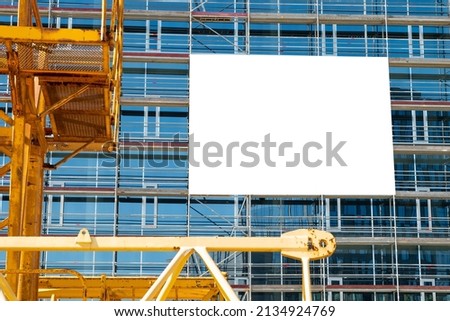 Blank white advertising banner on the wall of modern office building under construction