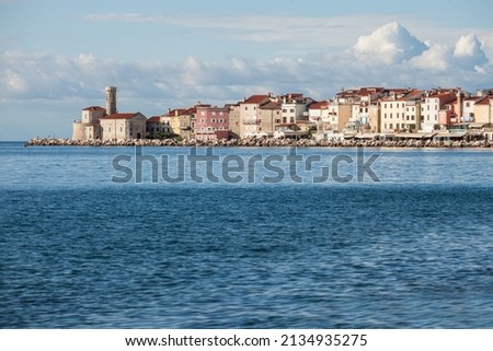 Panorama of  Piran, Slovenia, with the Adriatic sea in front, with blue water and sky, on a wharf  quay, during a sunny summer afternoon. Piran, or Pirano, is slovenian city on adriatic sea in istria Royalty-Free Stock Photo #2134935275