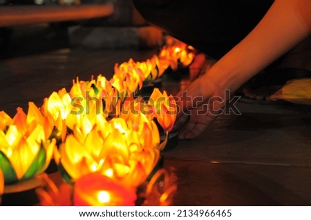 Blurred background, selective focus photo of a person's hand putting candles during Vesak day celebration. Royalty-Free Stock Photo #2134966465
