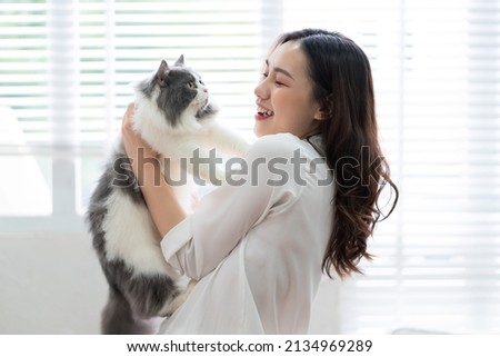 Young Asian woman playing with cat at home Royalty-Free Stock Photo #2134969289