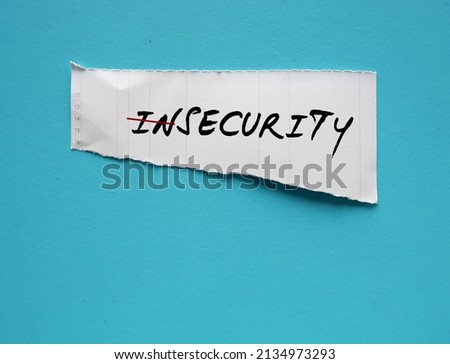 Torn paper on blue copy space background with handwriting INSECURITY change to SECURITY, concept of stop being insecure, or the fear that we are not good enough, and build self-esteem