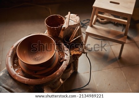 Picture of brown ceramic bowl and different tools in pottery workshop
