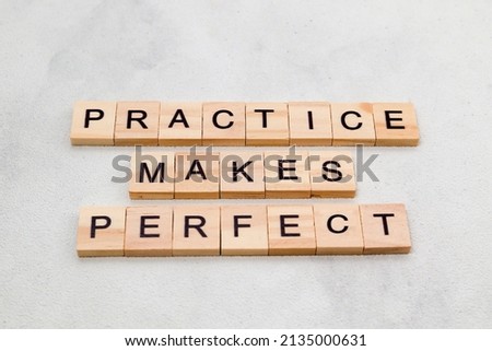 Top view of Practice Makes Perfect words on wooden cube letter block on white background. Business concept