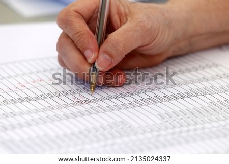 List of names. Close up on hand and pen.  Royalty-Free Stock Photo #2135024337