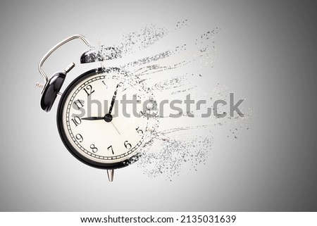 Retro black alarm clock dissolving into a little particles for time can not return and never wait anyone , Time management concept.