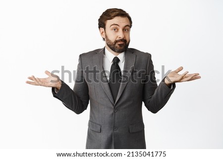I dont know. Clueless businessman shrugging shoulders, looking confused, puzzled to answer, have no idea, standing in work suit against white background Royalty-Free Stock Photo #2135041775