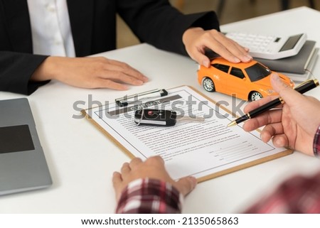 Car dealerships offer car title contracts for interest rates at their office desks. Royalty-Free Stock Photo #2135065863