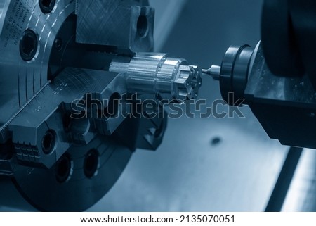 The  CNC lathe machine chamfering cut the metal shape parts. The hi-technology metal working processing by CNC turning machine . Royalty-Free Stock Photo #2135070051