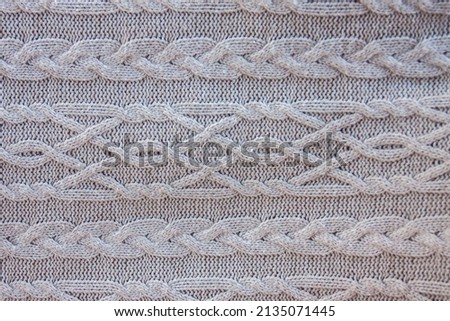 gray knitted background. closeup  warm knitted plaid in large knit with a pattern. free space
