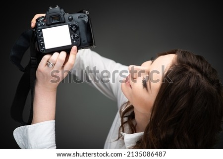 Cute girl photographer holding a professional camera in her hands. High quality photo