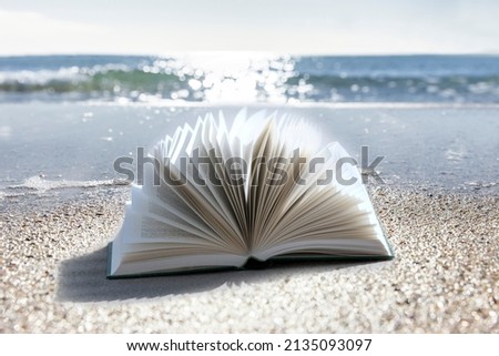Book on beach with sea in background
