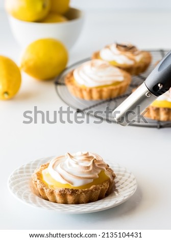 A lemon meringue tartlet with a blow torch to brown the top.