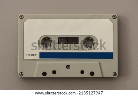 Outdated cassette tape from the 1970's isolated on beige background.