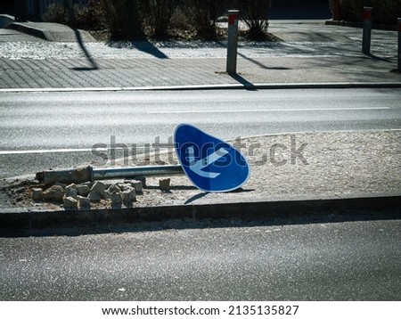 Broken road sign. road sign lies on the road Royalty-Free Stock Photo #2135135827