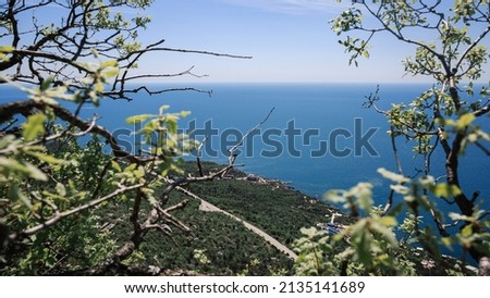 The coast of the Black Sea against the backdrop of mountains in the Crimea, a clear sunny summer day, blue sky and sea.